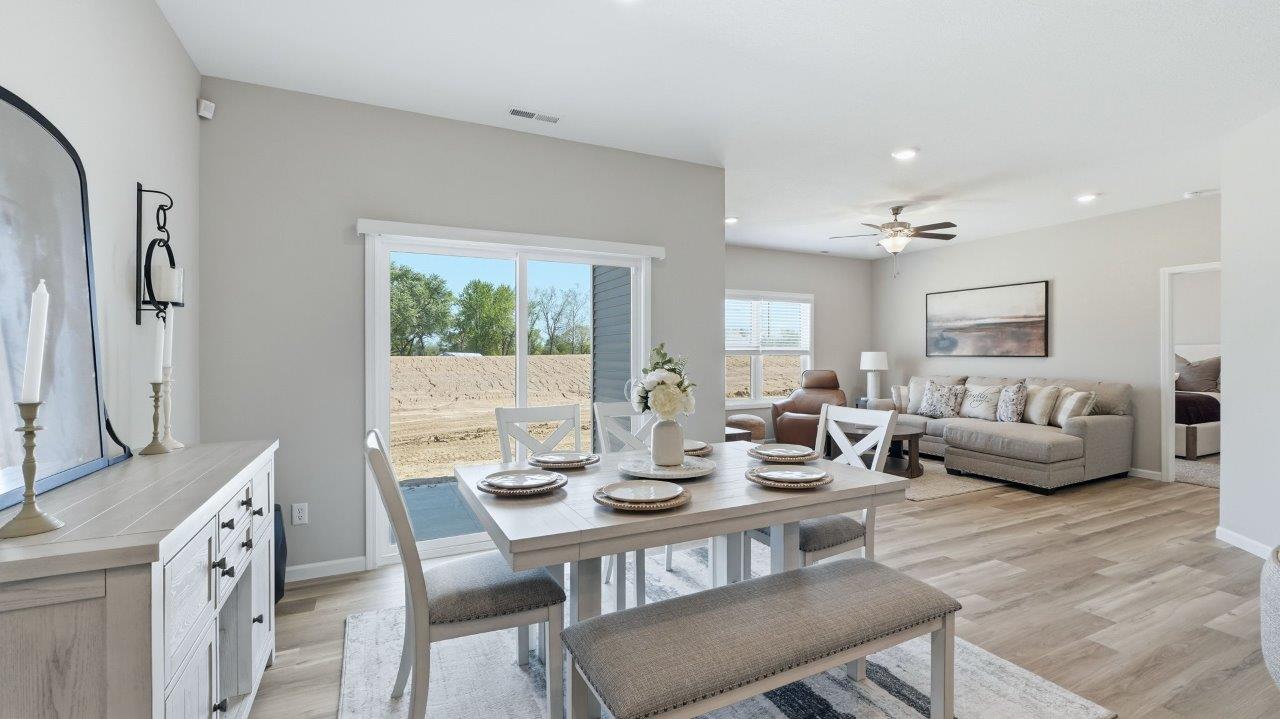 sierra ridge chatham dining room open layout with lvp flooring and sliding glass door to backyard patio