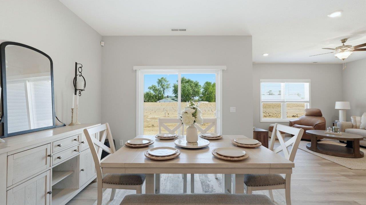 sierra ridge chatham dining room open layout with lvp flooring and sliding glass door to backyard patio