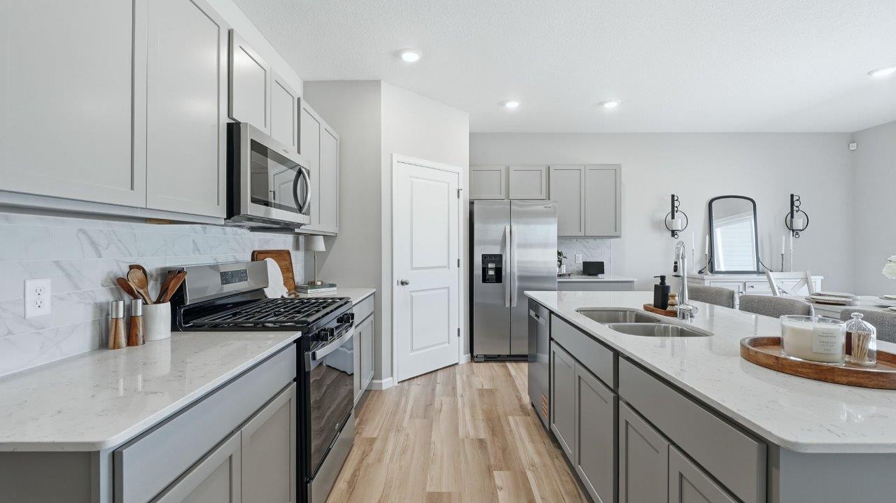 sierra ridge chatham kitchen gray cabinets, quartz counters, stainless steel appliances, corner pantry, and spacious island with bar seating