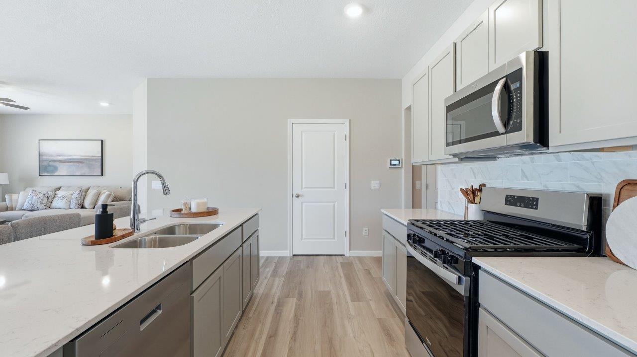 sierra ridge chatham kitchen gray cabinets, quartz counters, stainless steel appliances, corner pantry, and spacious island with bar seating