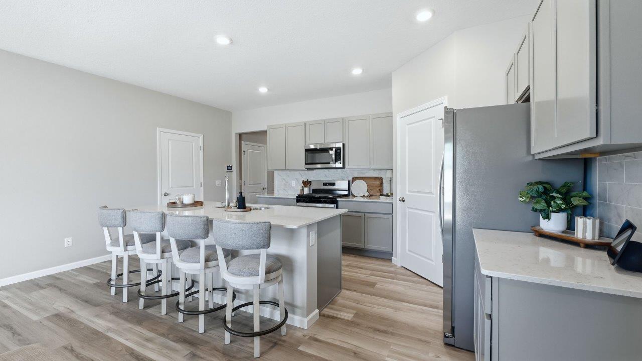 sierra ridge chatham kitchen gray cabinets, quartz counters, stainless steel appliances, corner pantry, and spacious island with bar seating