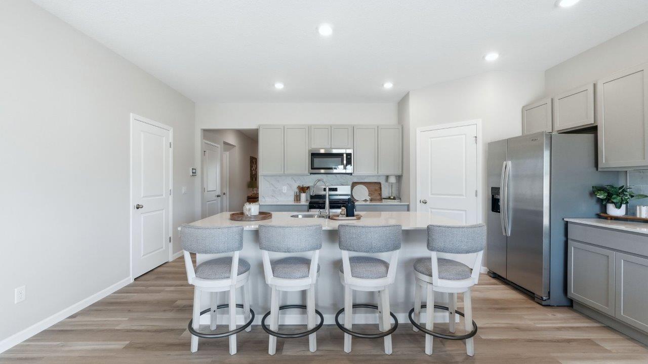 sierra ridge chatham kitchen gray cabinets, quartz counters, stainless steel appliances, corner pantry, and spacious island with bar seating