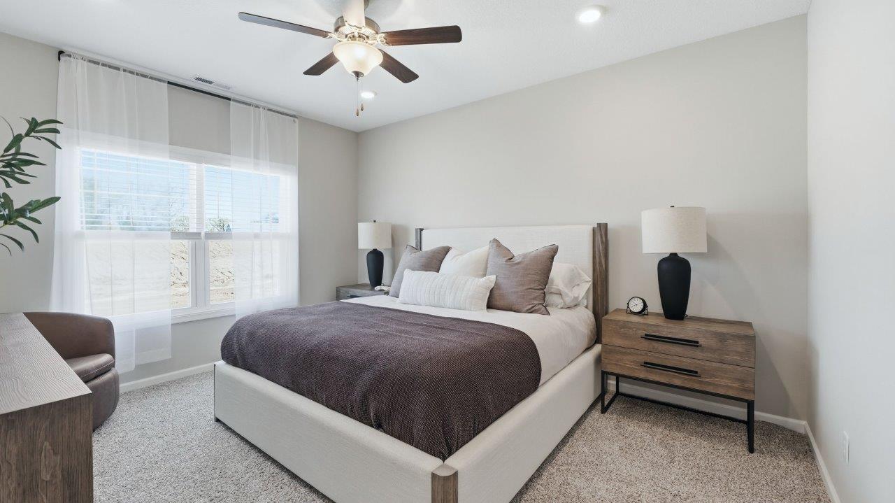 sierra ridge chatham primary bedroom with carpet flooring, ceiling fan, 1 windows, and ensuite bath and closet