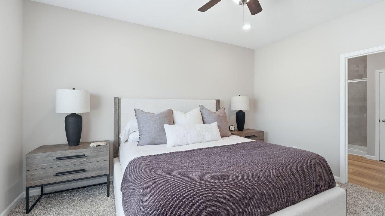 sierra ridge chatham primary bedroom with carpet flooring, ceiling fan, 1 windows, and ensuite bath and closet