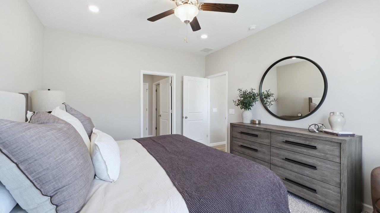 sierra ridge chatham primary bedroom with carpet flooring, ceiling fan, 1 windows, and ensuite bath and closet