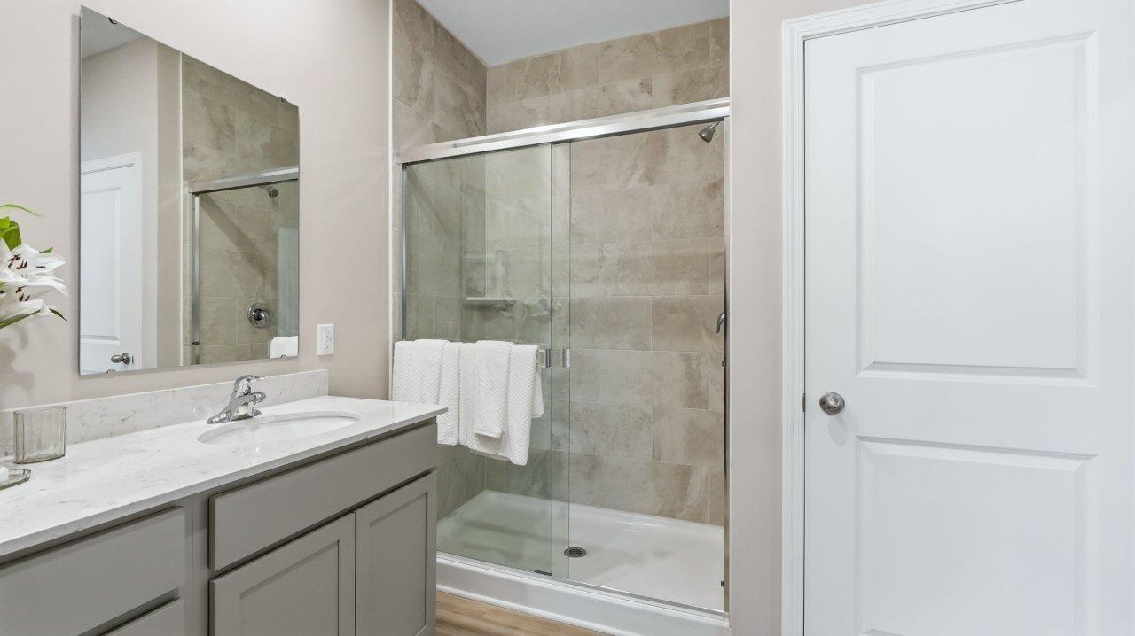 sierra ridge chatham primary bedroom ensuite bathroom with dual sinks, walk in shower, and private toilet room