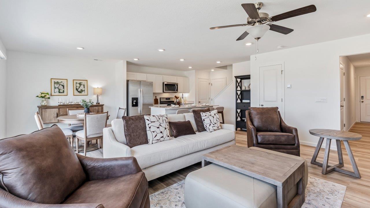 Whispering Pines Pattison Model - open layout living room with lvp flooring, ceiling fan, and white walls
