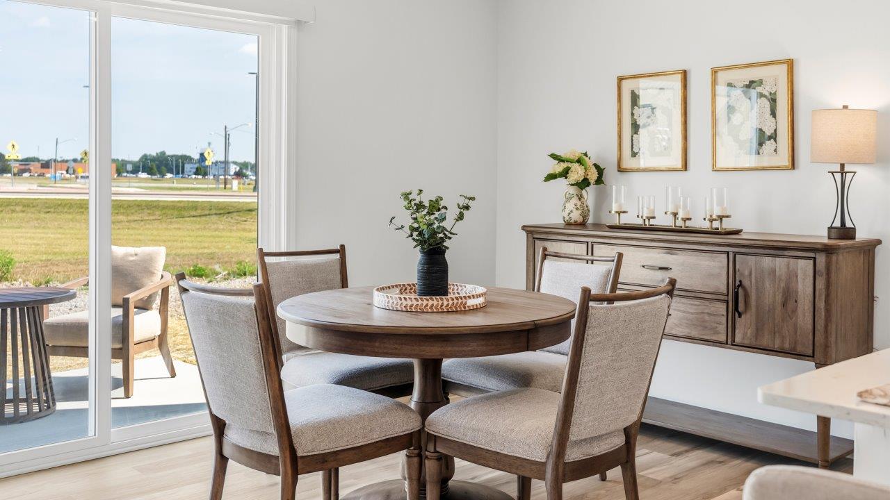 Whispering Pines Pattison Model - casual dining room with dining table, lvp flooring, and sliding glass door to backyard patio