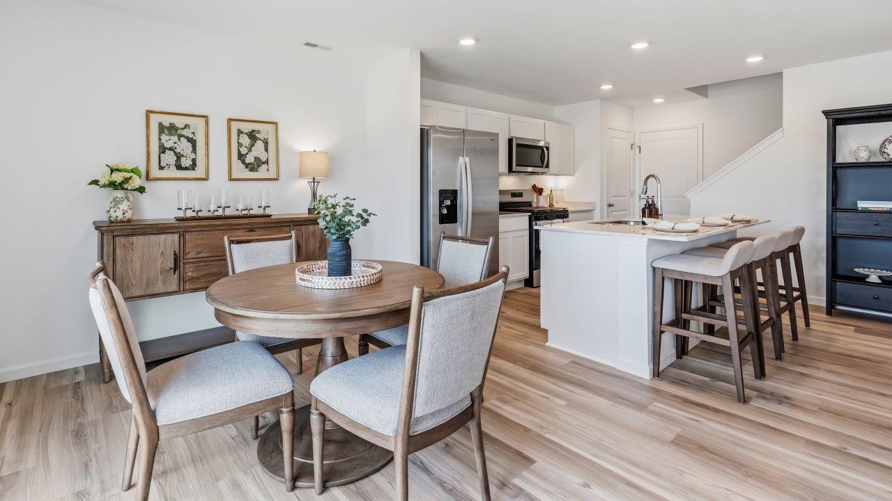 Whispering Pines Pattison Model - casual dining room with dining table, lvp flooring, and sliding glass door to backyard patio
