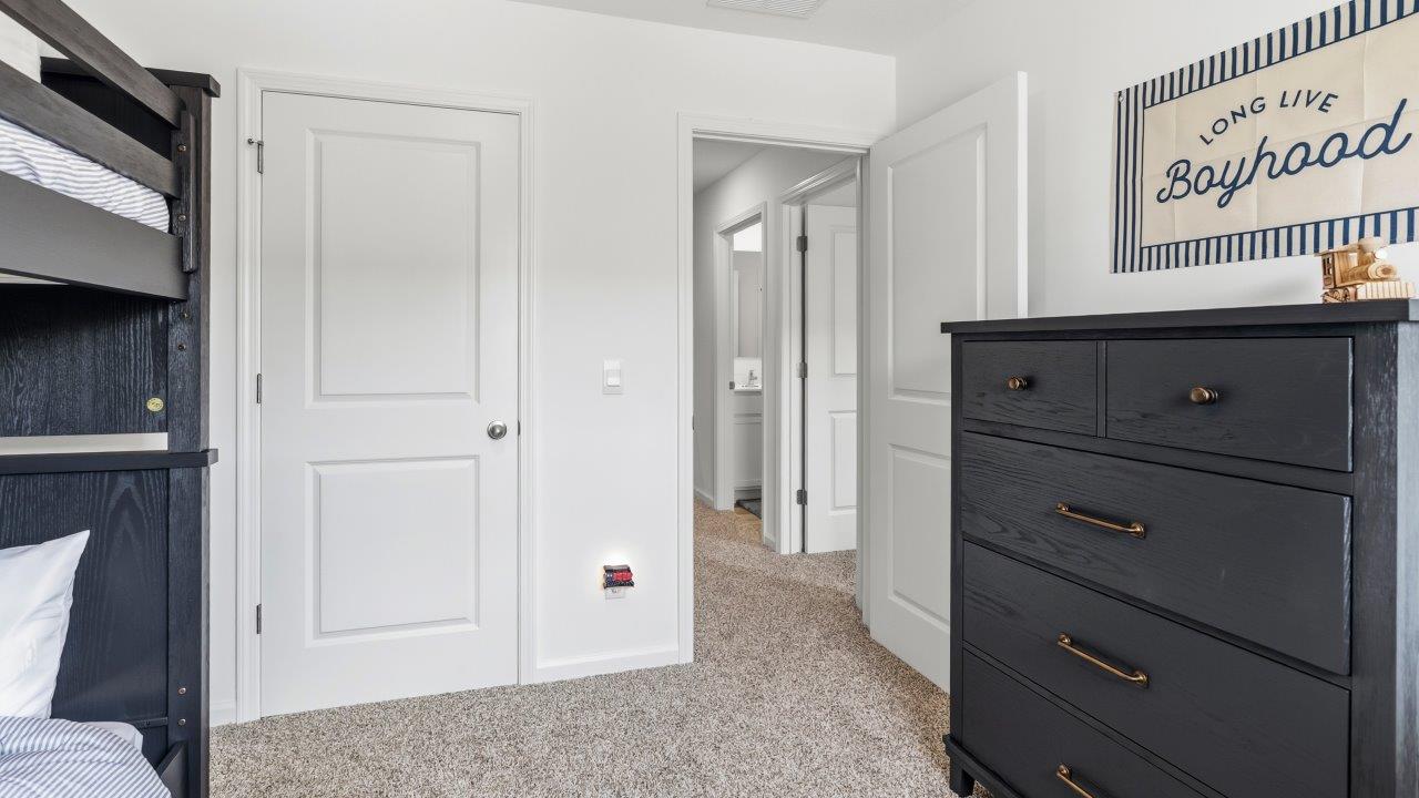Whispering Pines Pattison Model - bedroom 3 with single window, beige carpet flooring, white walls, furnished as children's room with bunk beds