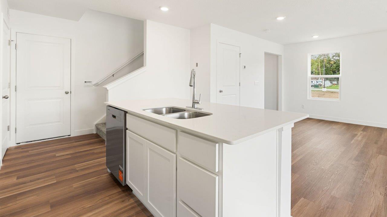 whispering pines portsmouth - kitchen with white cabinets, stainless steel appliances, quartz countertops, center island, and pantry
