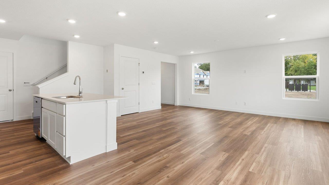 whispering pines portsmouth - kitchen with white cabinets, stainless steel appliances, quartz countertops, center island, and pantry