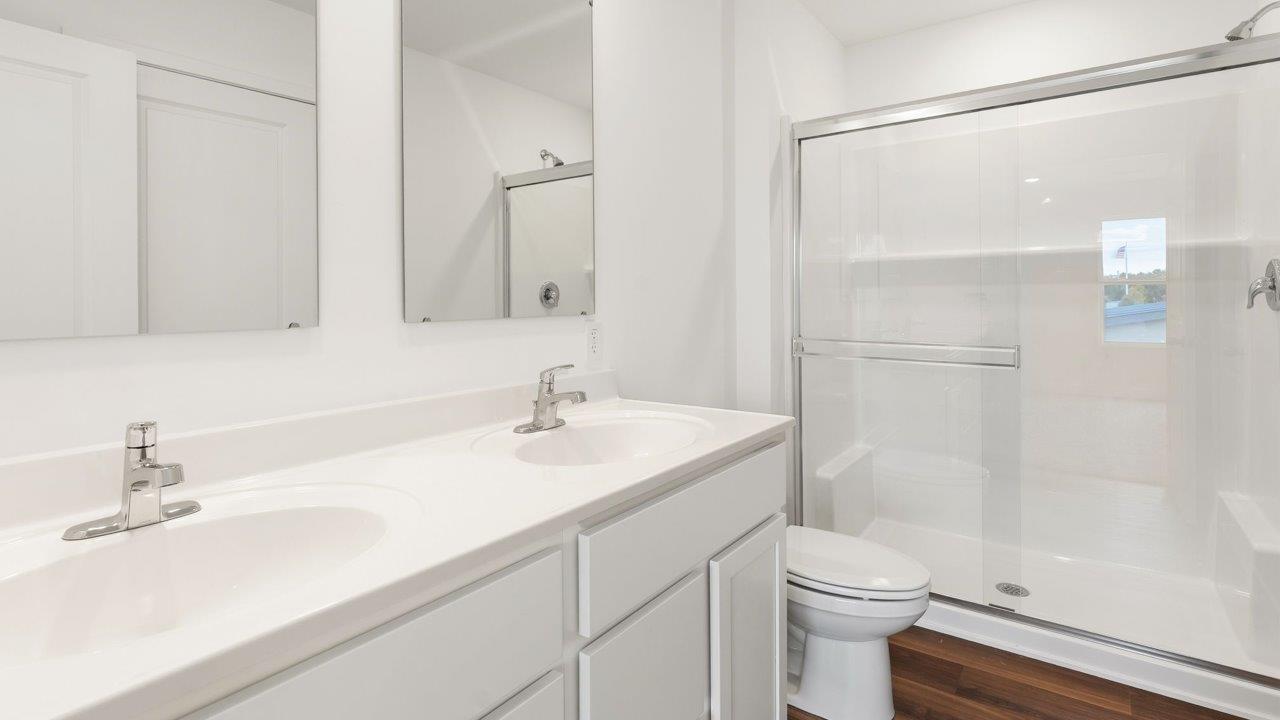 whispering pines portsmouth - primary bedroom ensuite bathroom with dual sink vanity and walk in shower