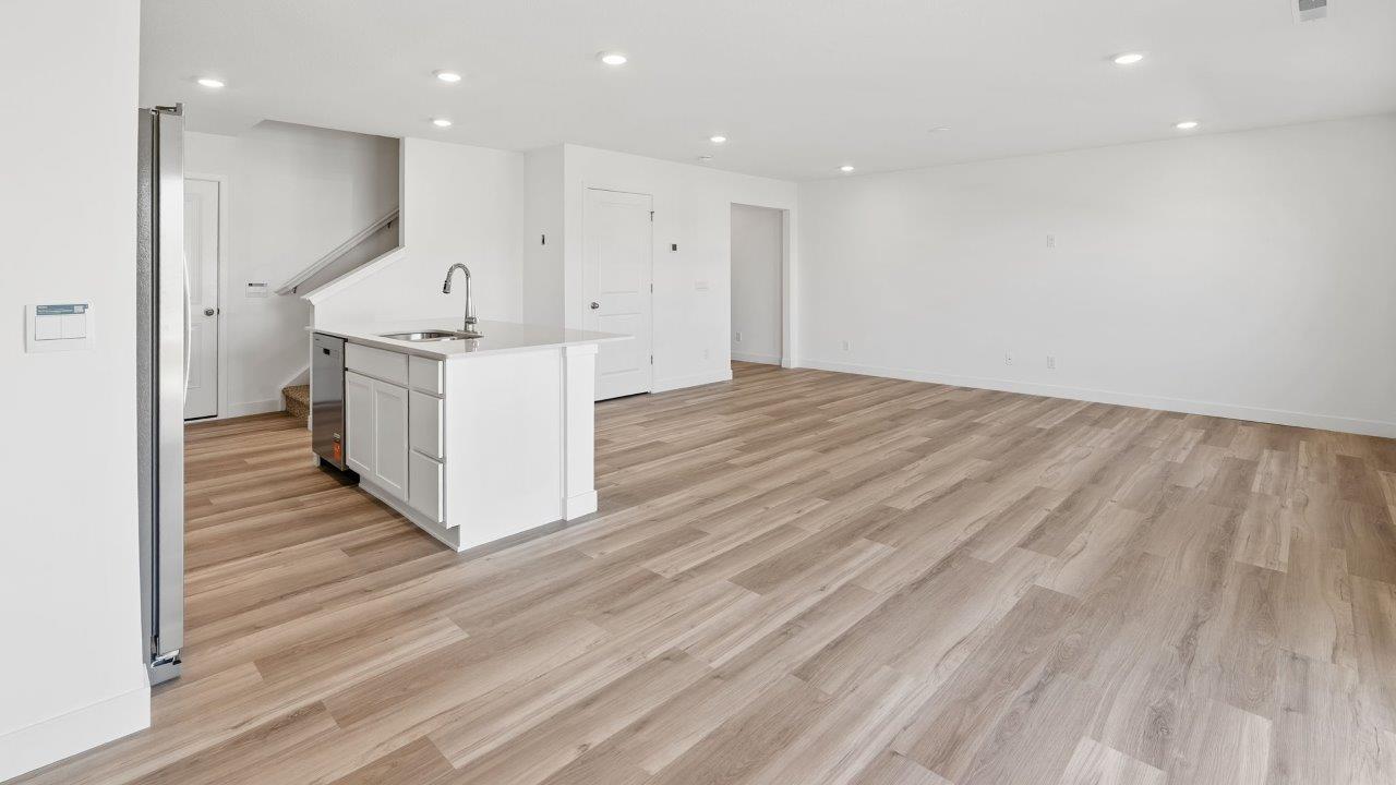 whispering pines portsmouth interior open layout living room with white walls, disc lighting, light mohawk lvp flooring