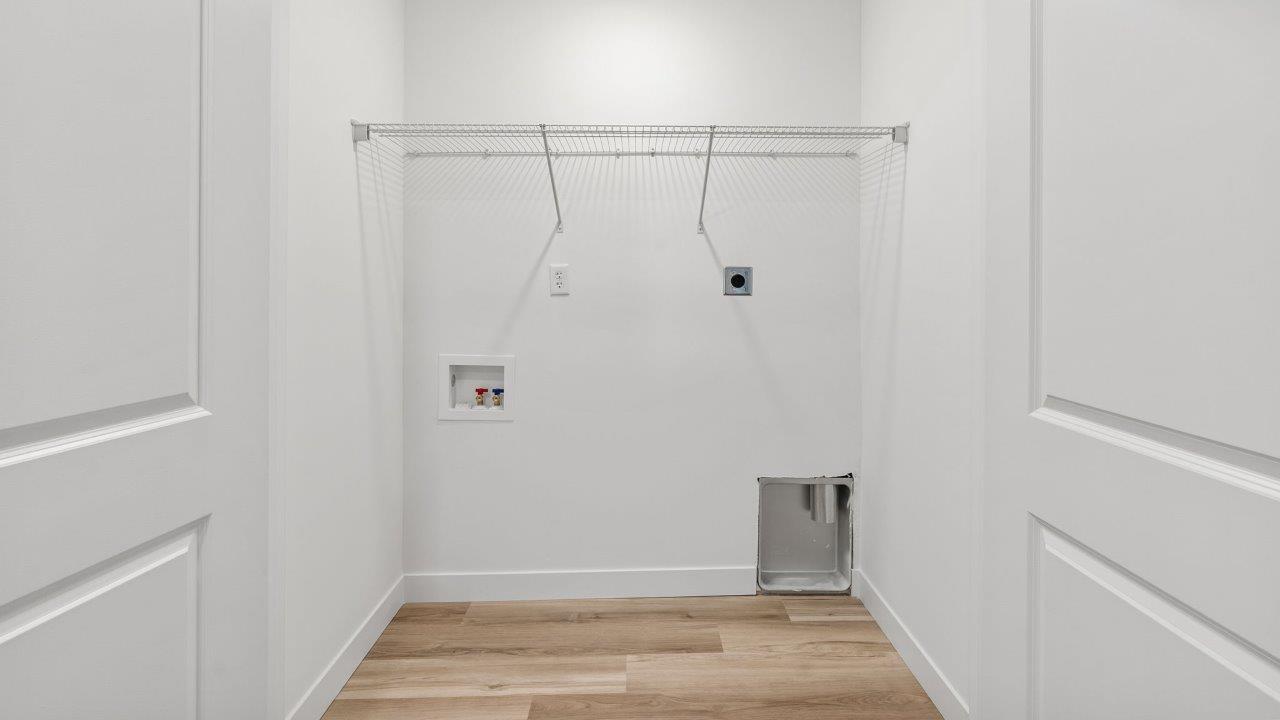 whispering pines portsmouth second floor laundry room with lvp flooring, built in shelf, and hookup for washer and dryer