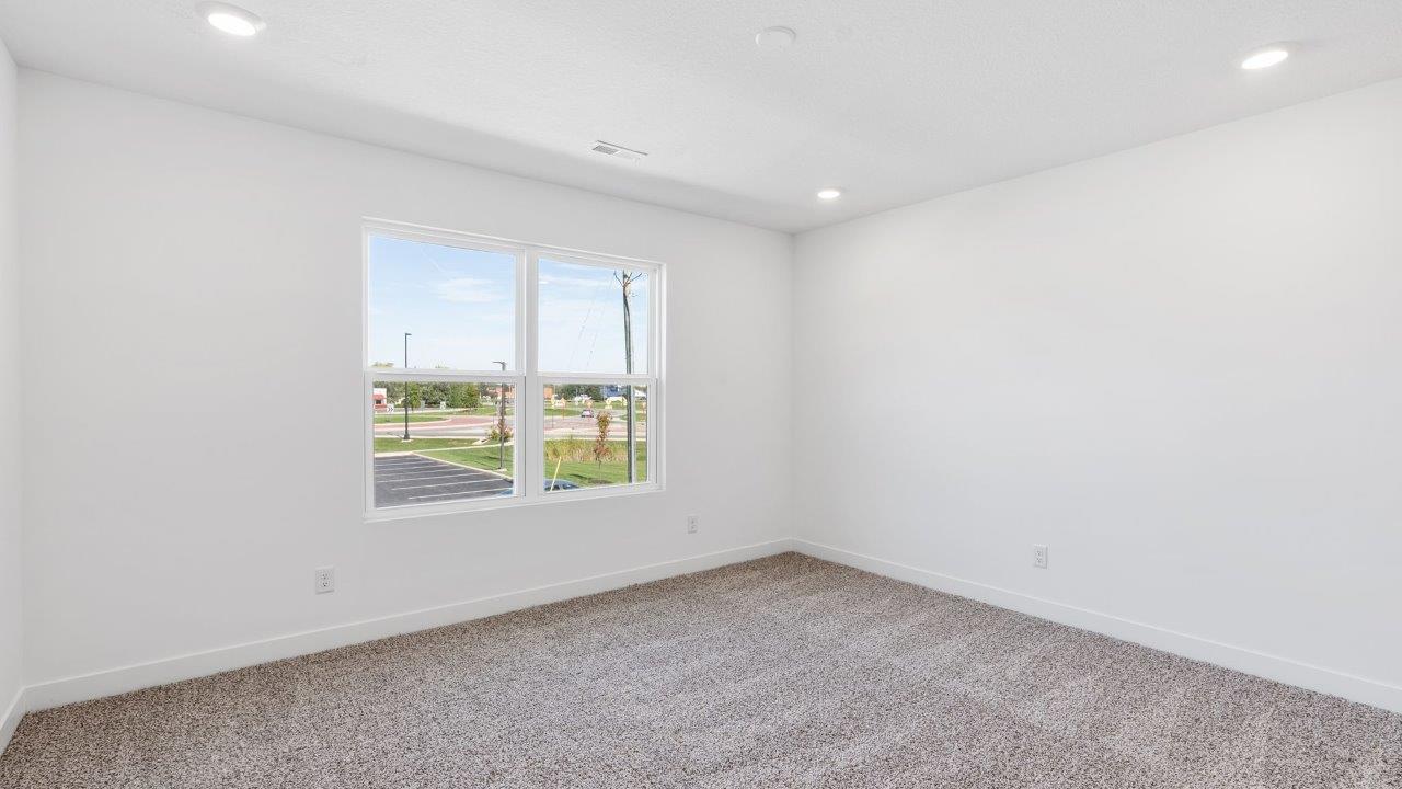 whispering pines portsmouth primary bedroom with elk beige carpet, white walls, 2 windows, and ensuite bathroom and walk-in closet