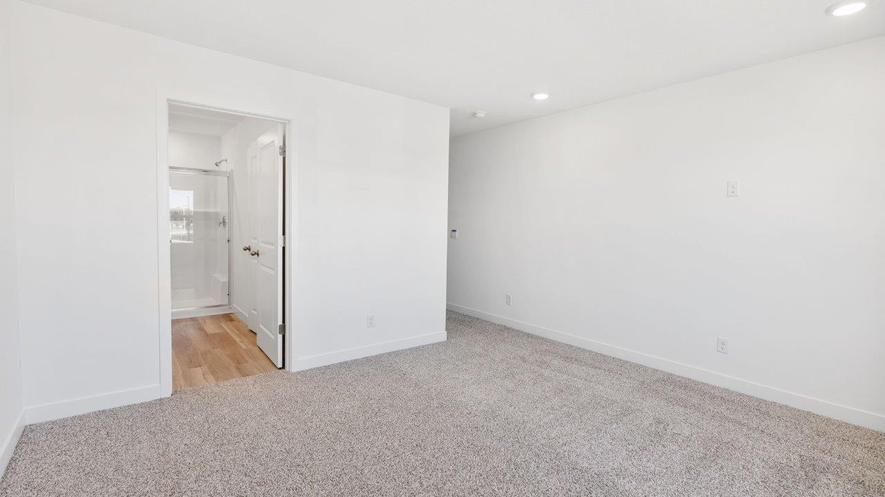 whispering pines portsmouth primary bedroom with elk beige carpet, white walls, 2 windows, and ensuite bathroom and walk-in closet