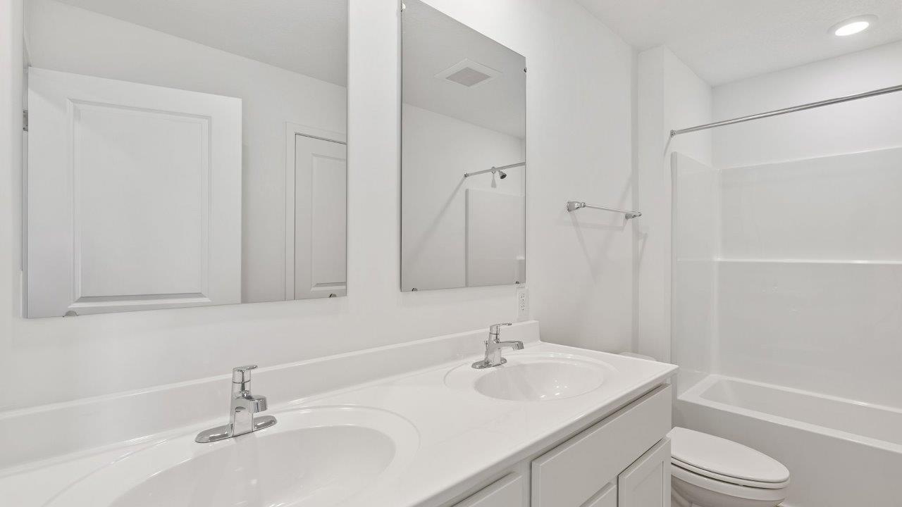 whispering pines portsmouth full bathroom with dual sink vanity, cultured white marble counters, mohawk lvp flooring, and tub shower