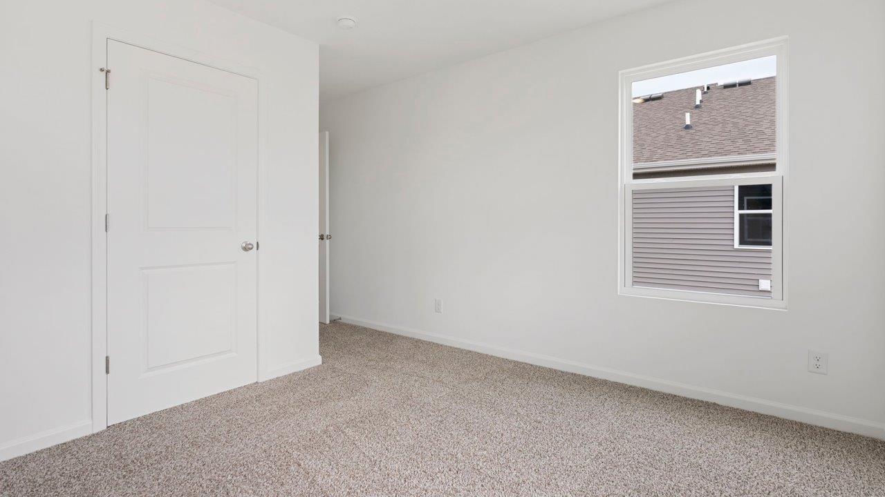 bedroom 4 with carpet flooring, 1 window, white walls, and ensuite closet