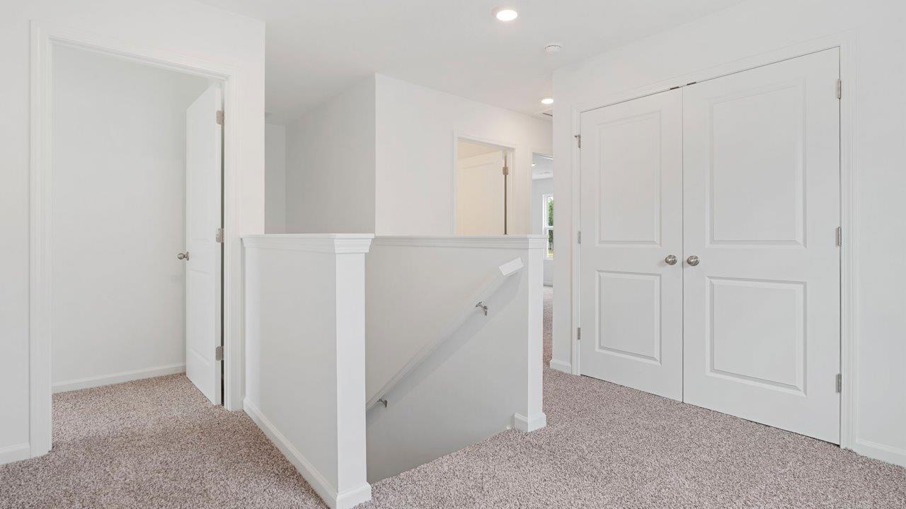 second floor landing with carpet flooring and white walls