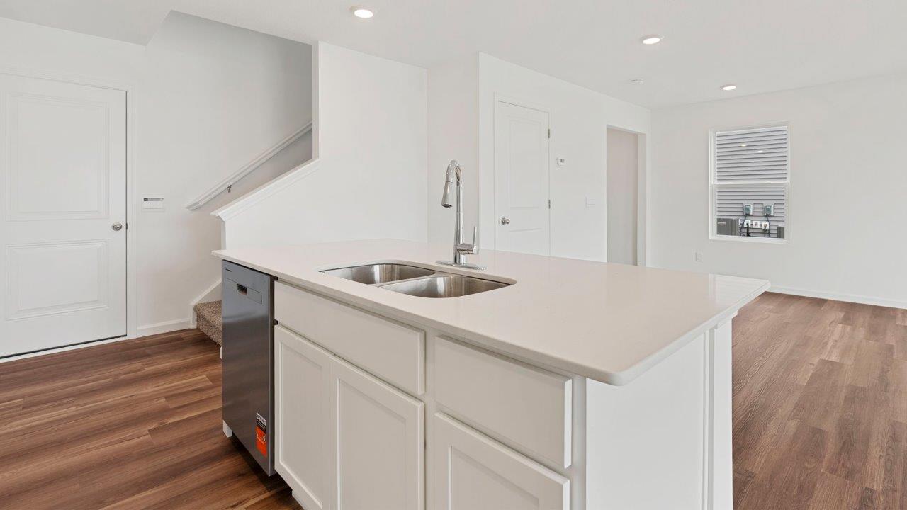 kitchen with quartz counters, white cabinets, stainless steel appliances, island, and pantry