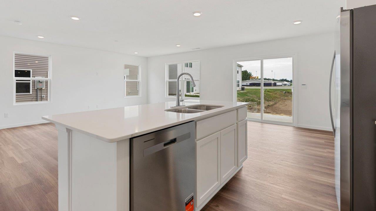 kitchen with quartz counters, white cabinets, stainless steel appliances, island, and pantry