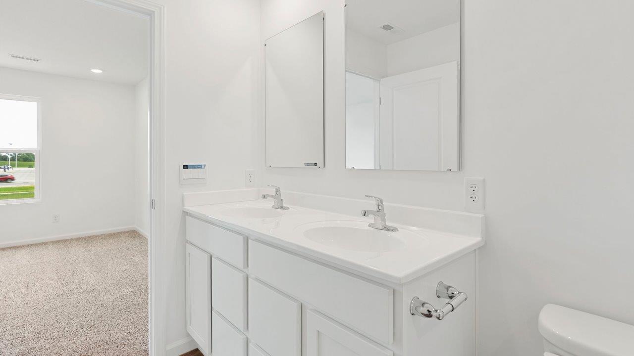 primary bedroom ensuite bathroom with dual sink vanity and walk in shower