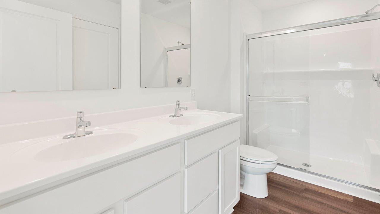 primary bedroom ensuite bathroom with dual sink vanity and walk in shower