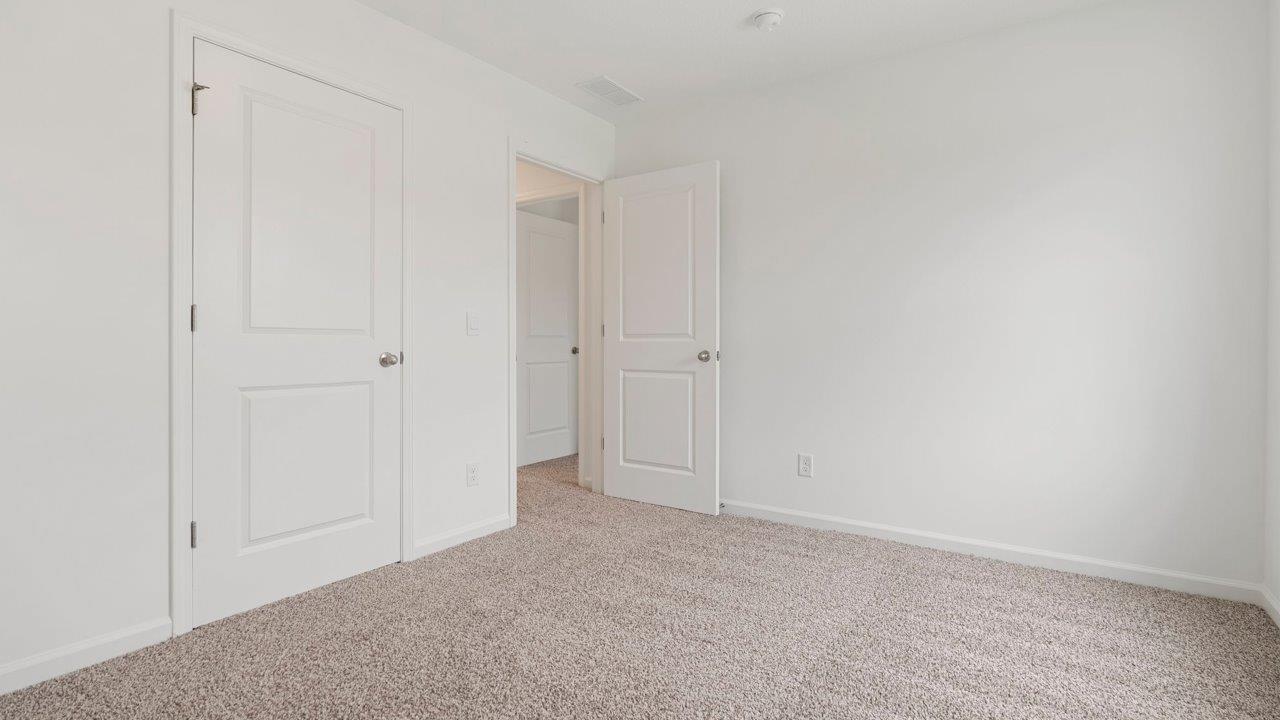 bedroom 2 with carpet flooring, 1 window, white walls, and ensuite closet