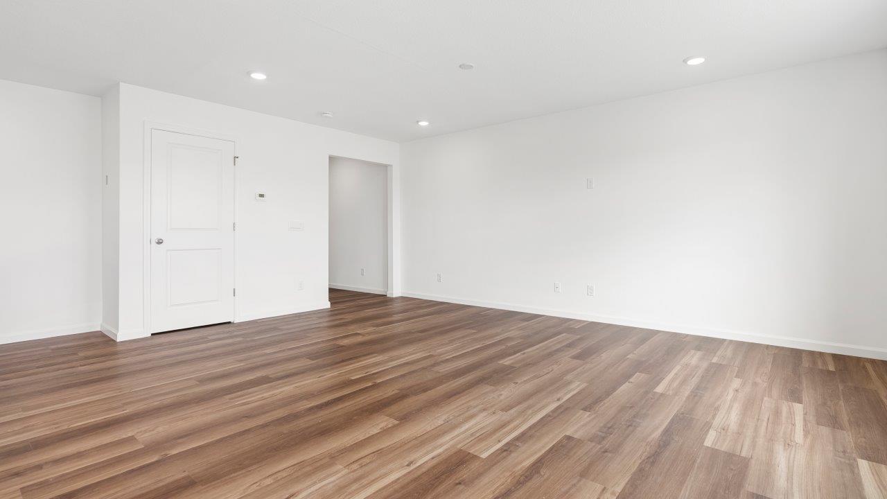 living room with mohawk luxury vinyl plank flooring, white walls, and 2 windows