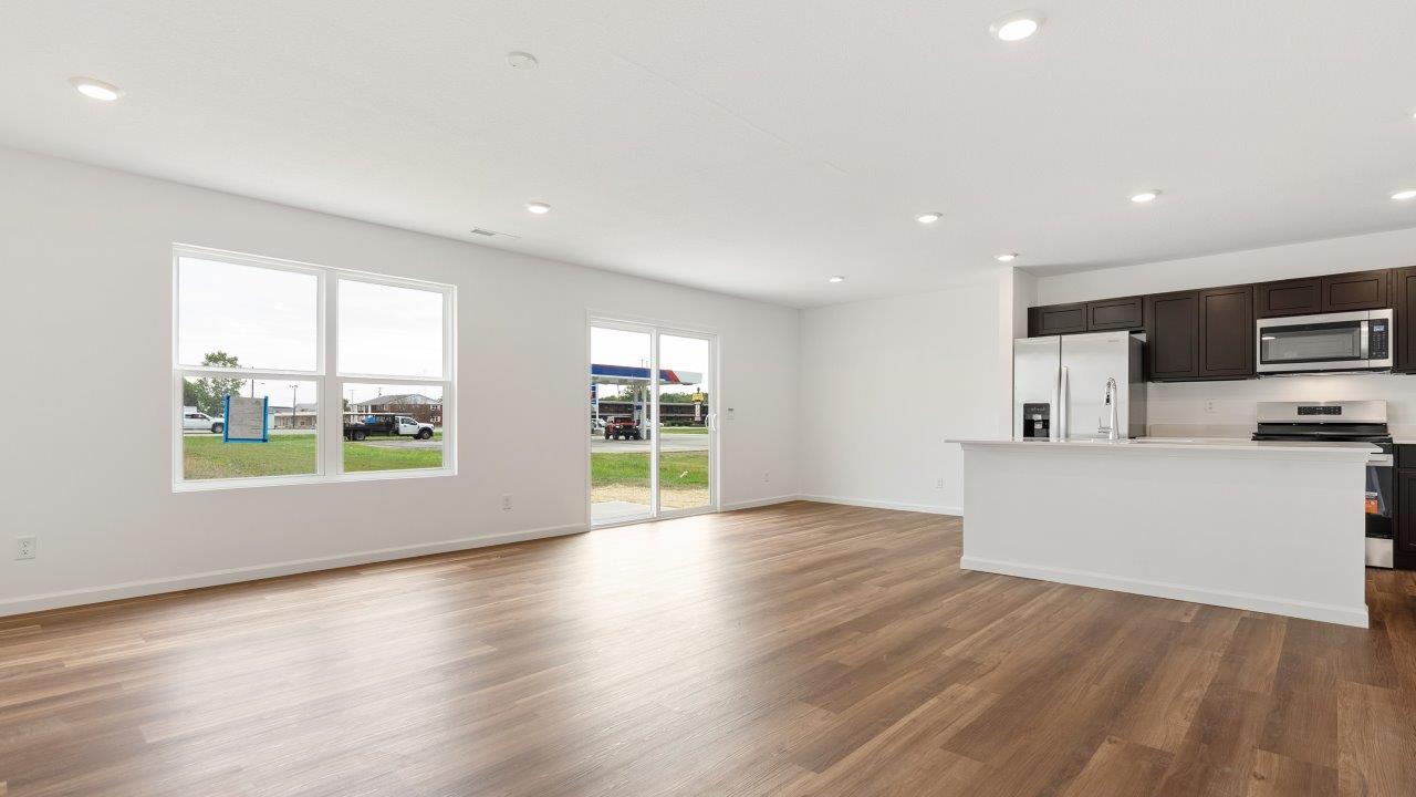 living room with mohawk luxury vinyl plank flooring, white walls, and 2 windows