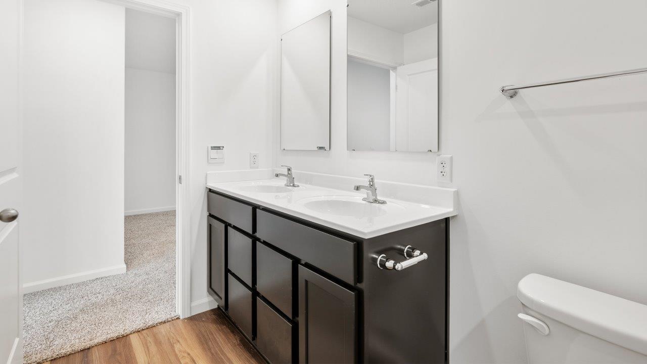 full bathroom with dual sink vanity and tub shower