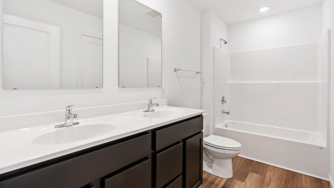 full bathroom with dual sink vanity and tub shower
