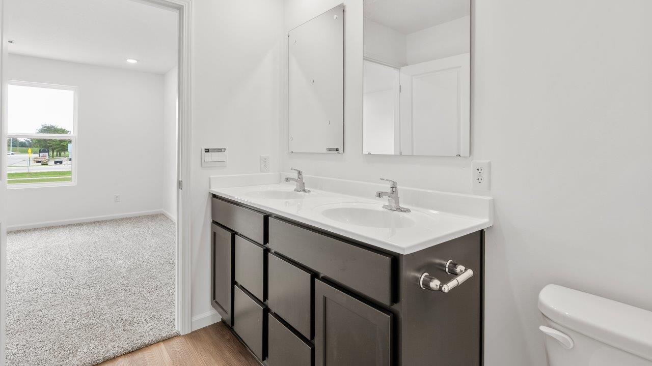 primary bedroom ensuite bathroom with dual sink vanity and walk in shower