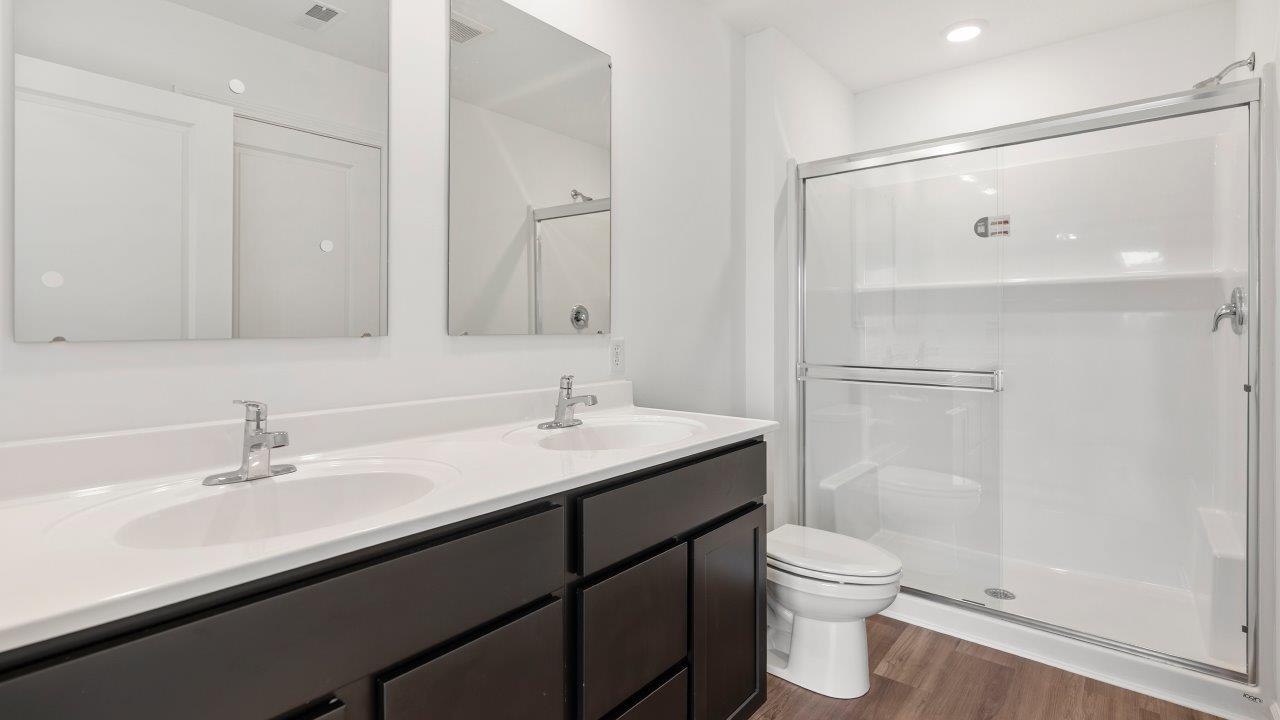 primary bedroom ensuite bathroom with dual sink vanity and walk in shower