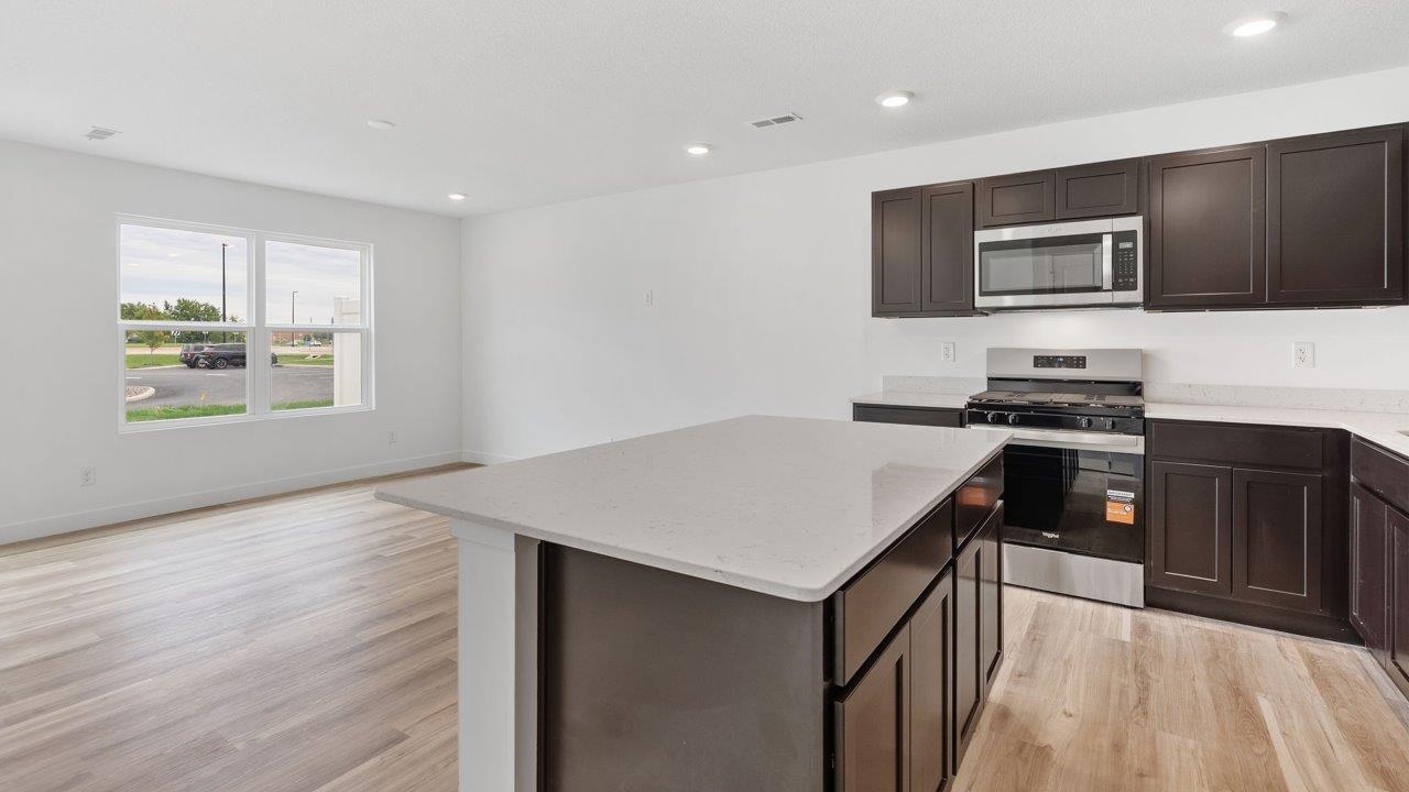 whispering pines pearson - kitchen with sarsaparilla, stainless steel appliances, quartz countertops, and center island