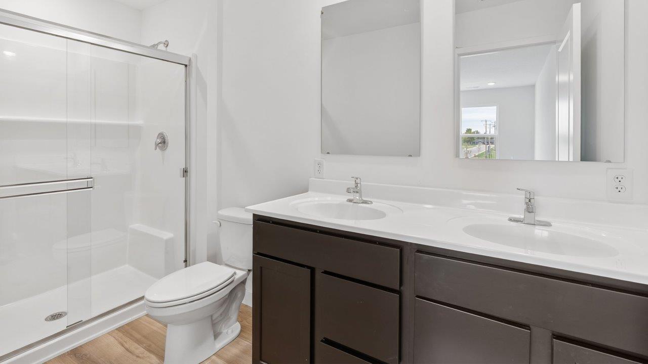whispering pines pearson - primary ensuite bathroom with dual sink vanity and walk in shower