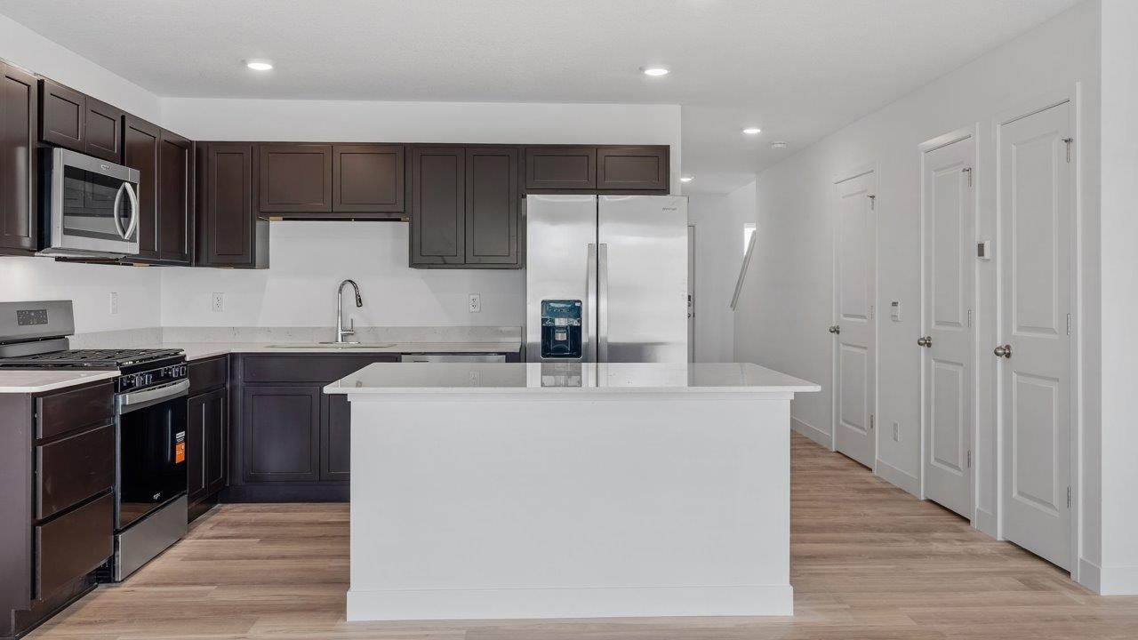whispering pines pearson - kitchen with sarsaparilla, stainless steel appliances, quartz countertops, and center island