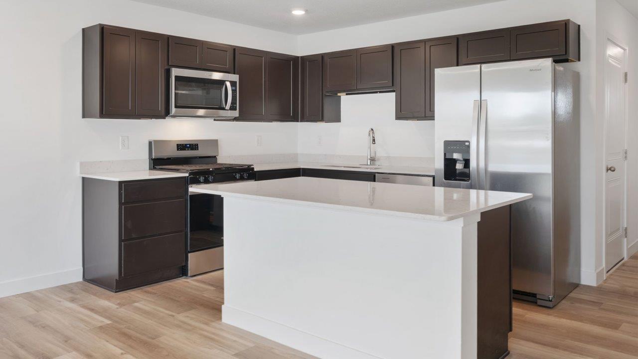 whispering pines pearson - kitchen with sarsaparilla, stainless steel appliances, quartz countertops, and center island