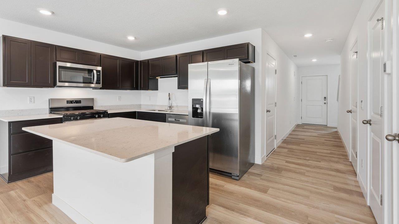 whispering pines pearson - kitchen with sarsaparilla, stainless steel appliances, quartz countertops, and center island