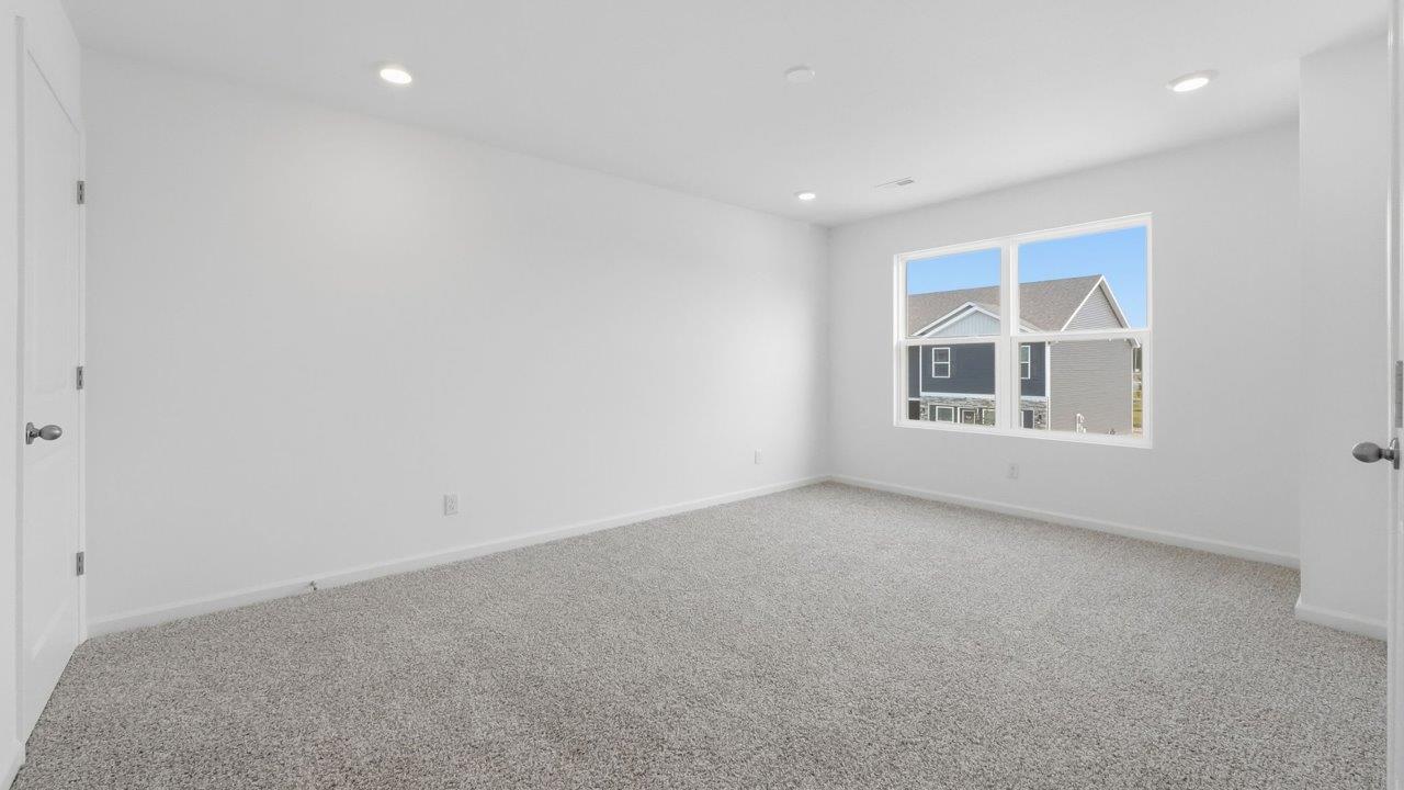 whispering pines pearson primary bedroom with beige carpet, white walls, and ensuite bathroom and walk in closet