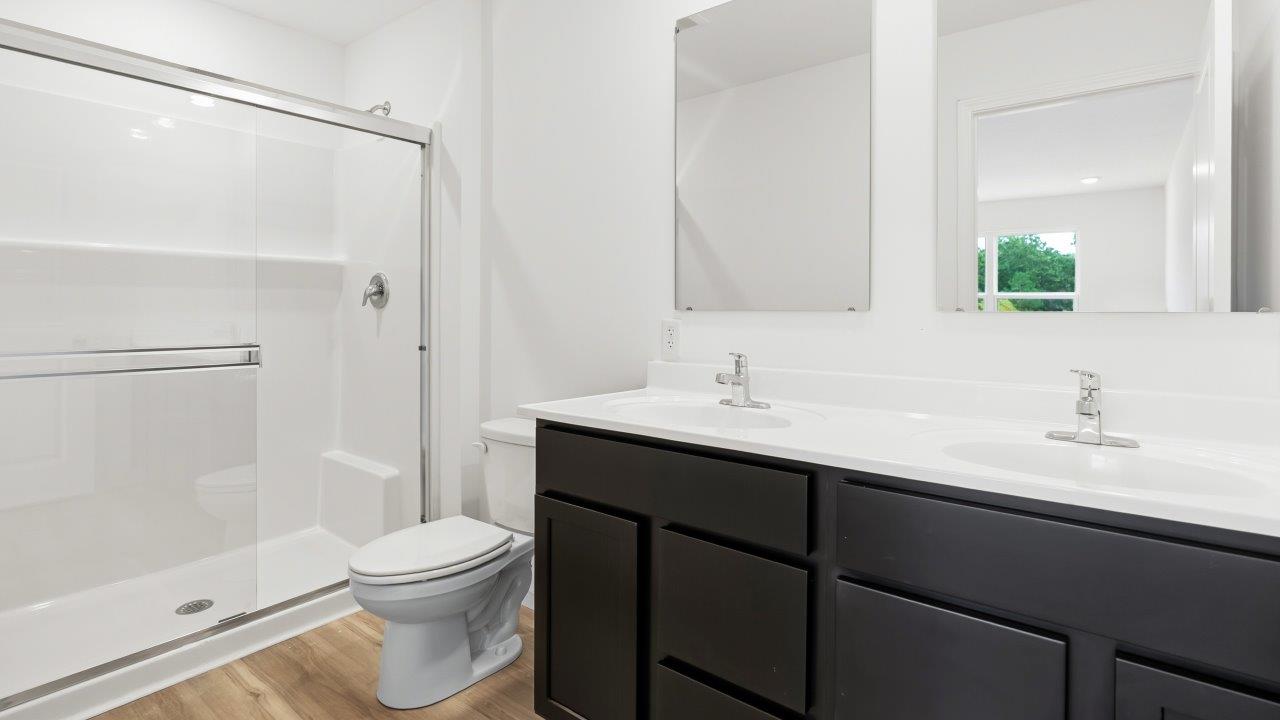 primary bedroom ensuite bathroom with dual sink vanity and walk in shower