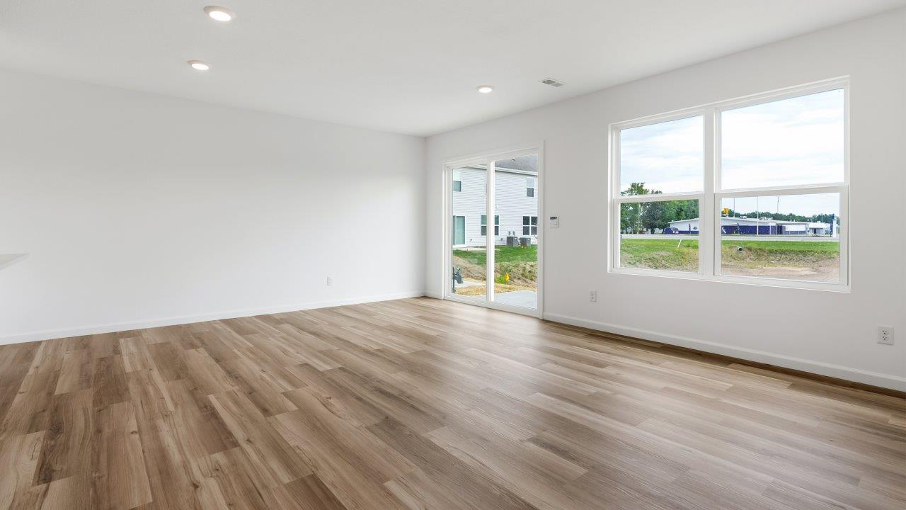 open concept living room with lvp flooring and white walls