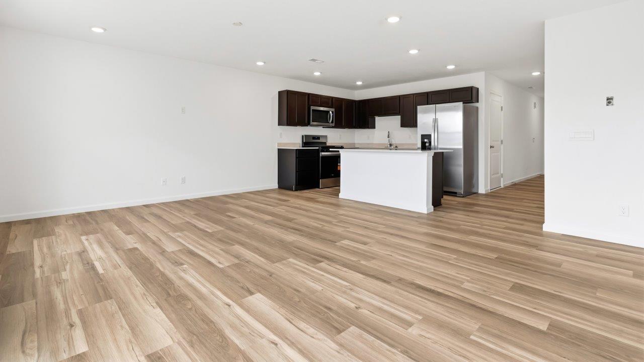 open concept living room with lvp flooring and white walls