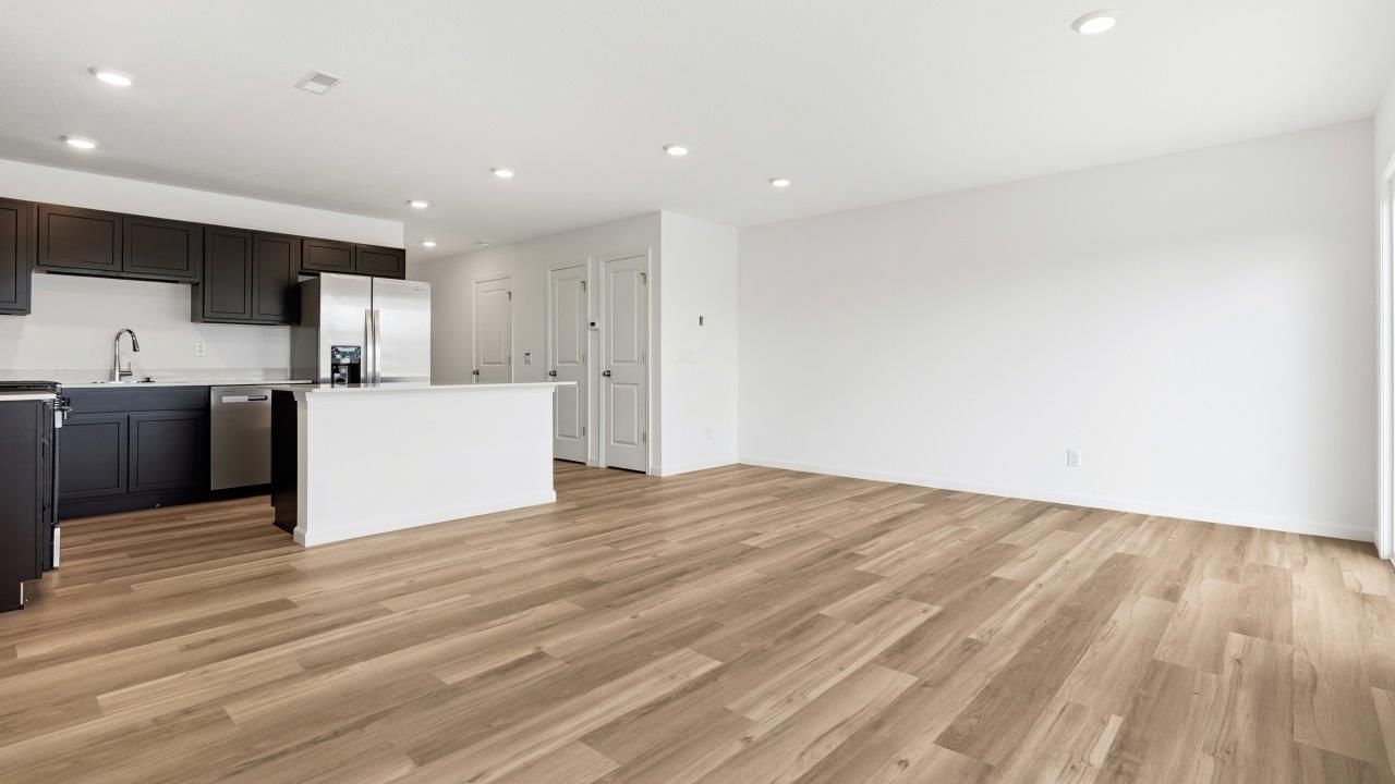 open concept living room with lvp flooring and white walls