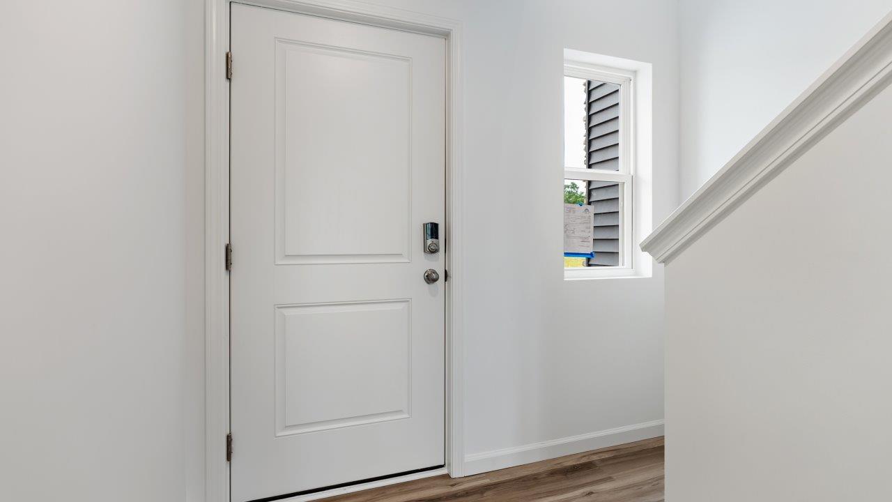 front door and foyer with lvp flooring and white walls