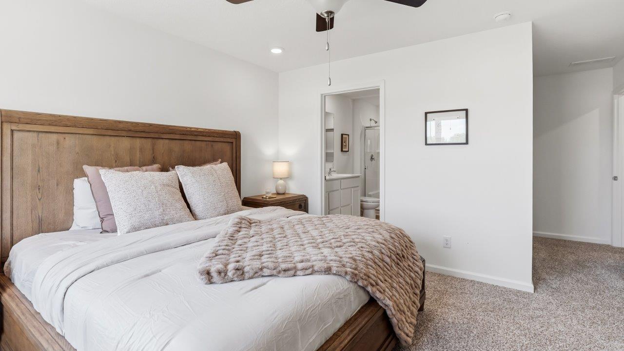 whispering pines pattison plan interior model home - primary bedroom with ensuite bathroom and walk in closet