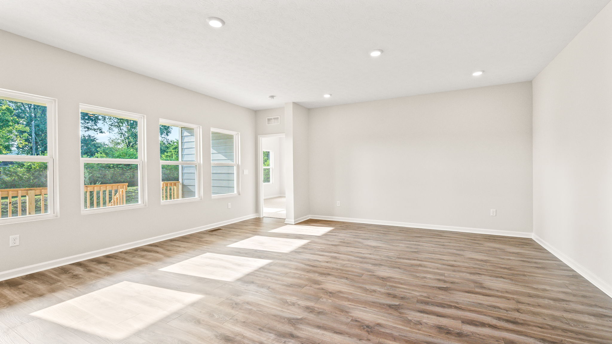 Living room area with windows to backyard