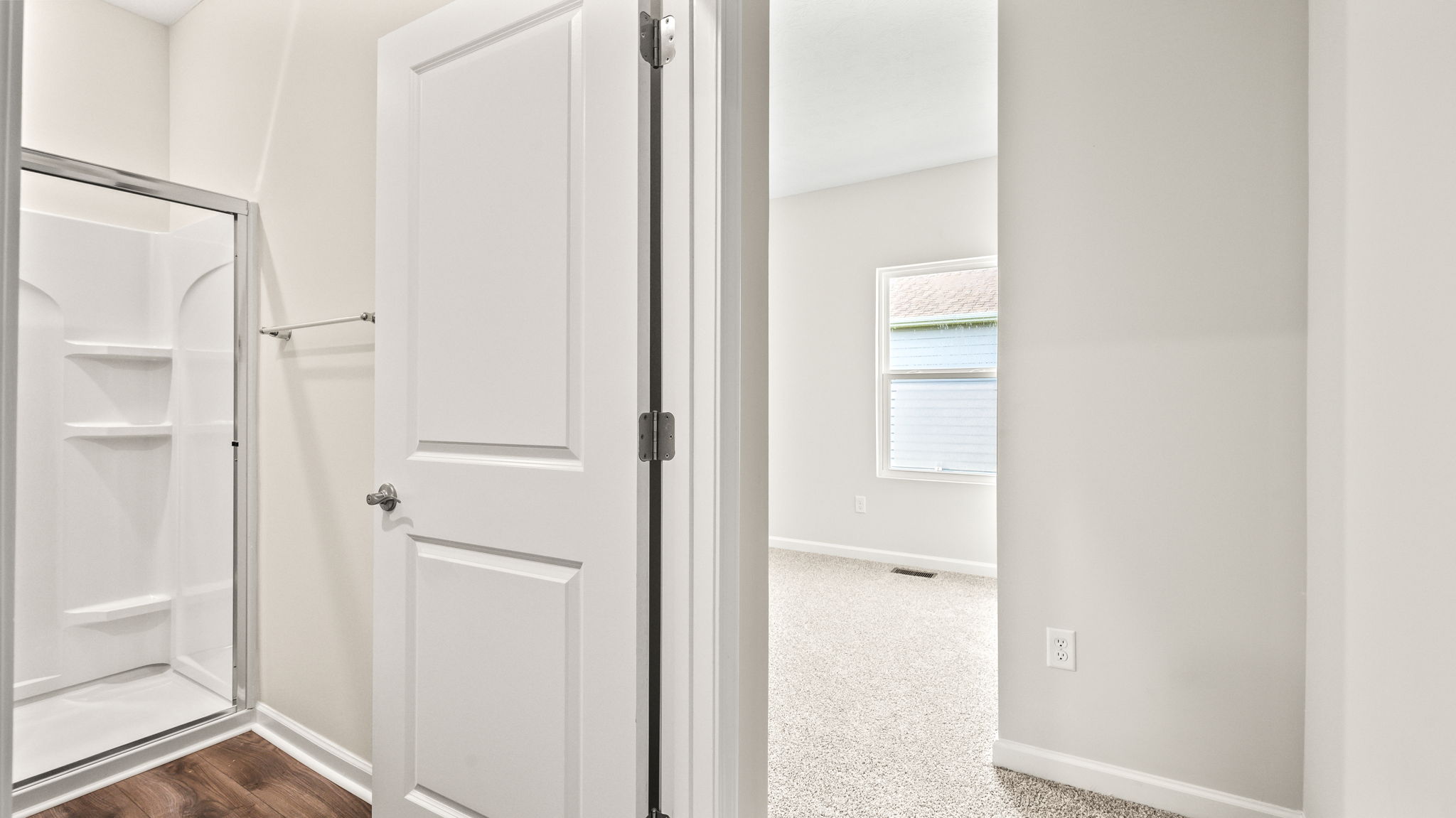 View of transition between primary bedroom and bathroom suite