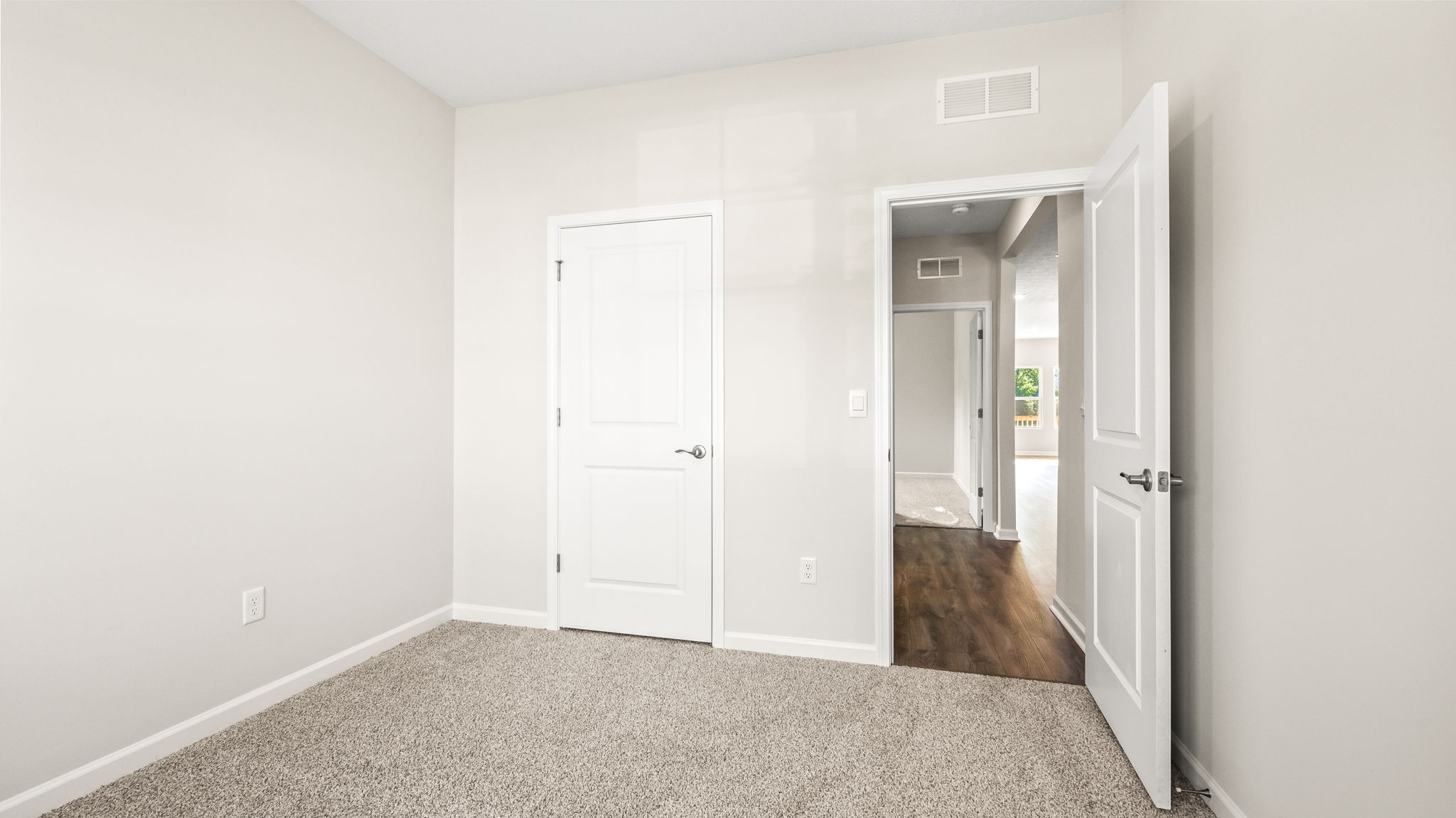 Carpeted bedroom with door to closet